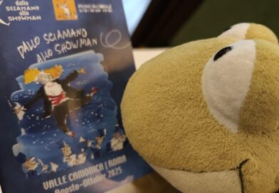 Anche i pupazzi leggono tra le righe: Geco Gaudenzio si prepara al festival “Dallo Sciamano allo Showman”, dove la cultura danza tra fumetti, musica e poesia in Valle Camonica.