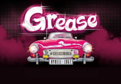 Locandina del musical Grease con auto rosa anni '50 e scritta Grease, promozione spettacolo al Teatro Repower 2026