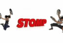 Artisti di STOMP in salto con bidoni sul palco, simbolo del ritmo urbano dello spettacolo al Teatro Lirico di Milano