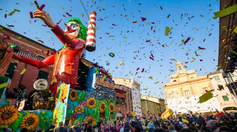 Carnevale di Cento in pullman da Milano: folla in festa e carri allegorici colorati durante la sfilata in piazza