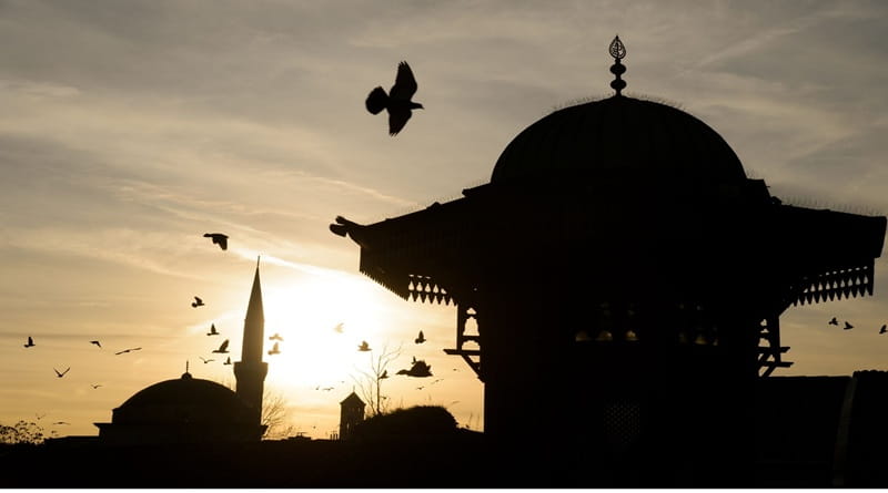 Moschea di Sarajevo al tramonto con minareto e cupola in controluce, simbolo del viaggio a Sarajevo nel cuore dei Balcani, Bosnia ed Erzegovina.