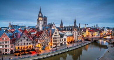 Veduta serale di una città storica in Belgio con canale, case medievali illuminate e architettura fiamminga, atmosfera tipica del viaggio in Vallonia.