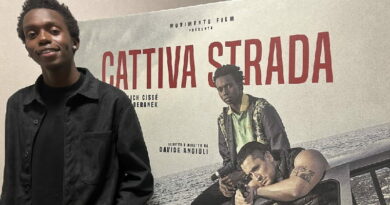 Malich Cissé davanti al poster del film Cattiva strada di Davide Angiuli con Giulio Beranek, film italiano ambientato a Bari