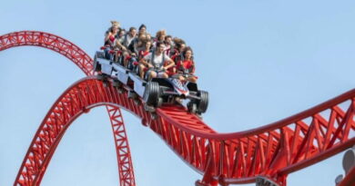 montagne russe Mirabilandia con persone in corsa su roller coaster rosso nel parco divertimenti in Romagna
