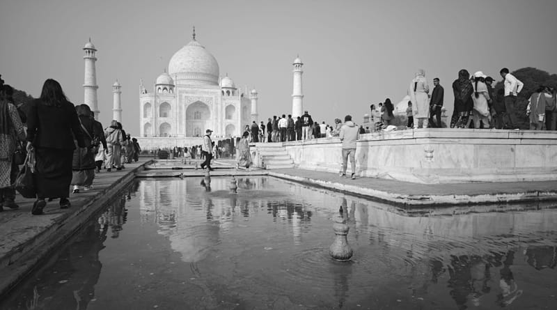 Turisti davanti al Taj Mahal di Agra tra foschia e riflessi d’acqua, simbolo dell’India romantica e monumentale nel cuore dell’Uttar Pradesh