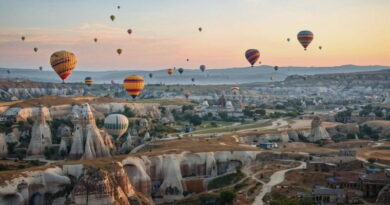 Mongolfiere all’alba sopra la Cappadocia in Turchia con camini delle fate e paesaggi rocciosi durante un tour organizzato