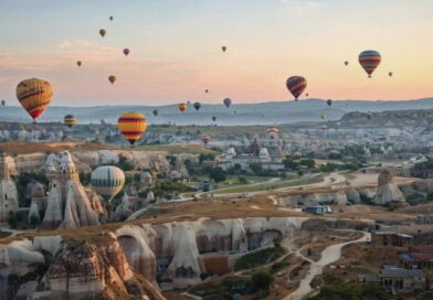Mongolfiere all’alba sopra la Cappadocia in Turchia con camini delle fate e paesaggi rocciosi durante un tour organizzato