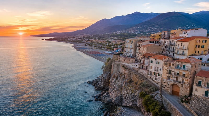 Veduta panoramica della Riviera dei Cedri in Calabria al tramonto, con il borgo affacciato sul mare Tirreno tra spiagge, scogliere e montagne della costa calabrese.