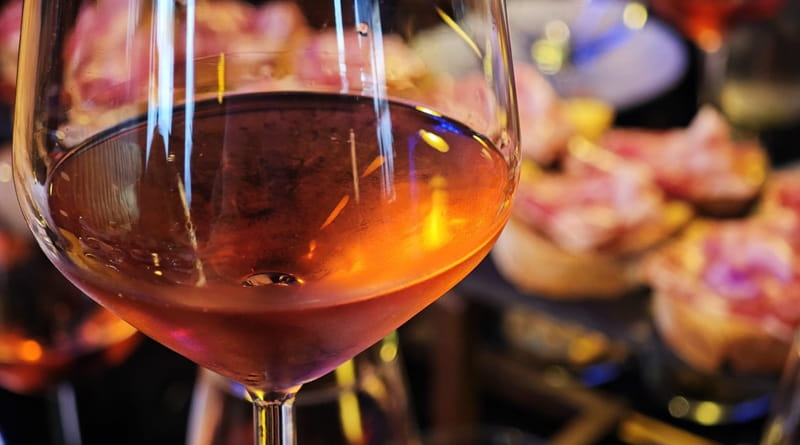 Degustazione di vini dell'Isola d'Elba durante l'evento EustachiORA Milano con calice di rosato e specialità gastronomiche