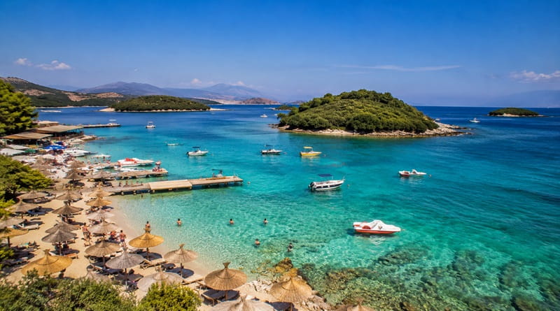 Spiaggia di Ksamil durante la Zingarata Radio Vacanze in Albania del sud con mare cristallino e isole.