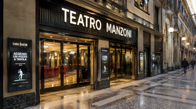 Ingresso del Teatro Manzoni Milano illuminato di sera, sede della stagione teatrale 2026-2027 con abbonamenti e spettacoli di prosa.
