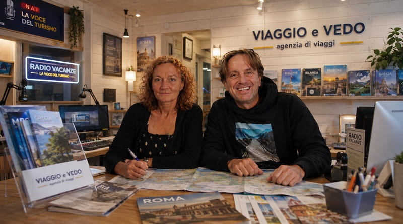Piera e Gianluigi accolgono i viaggiatori nell'agenzia Viaggio e Vedo di Roma, un ambiente caldo con pareti in legno dove convivono consulenza di viaggio e gli studi di Radio Vacanze, punto di riferimento per turismo ed esperienze personalizzate.